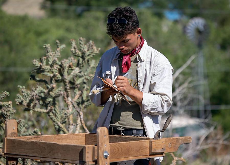 学生Field Demitri DeLeon records information about artifacts年度in the之上. (Photo by Tom Connelly)